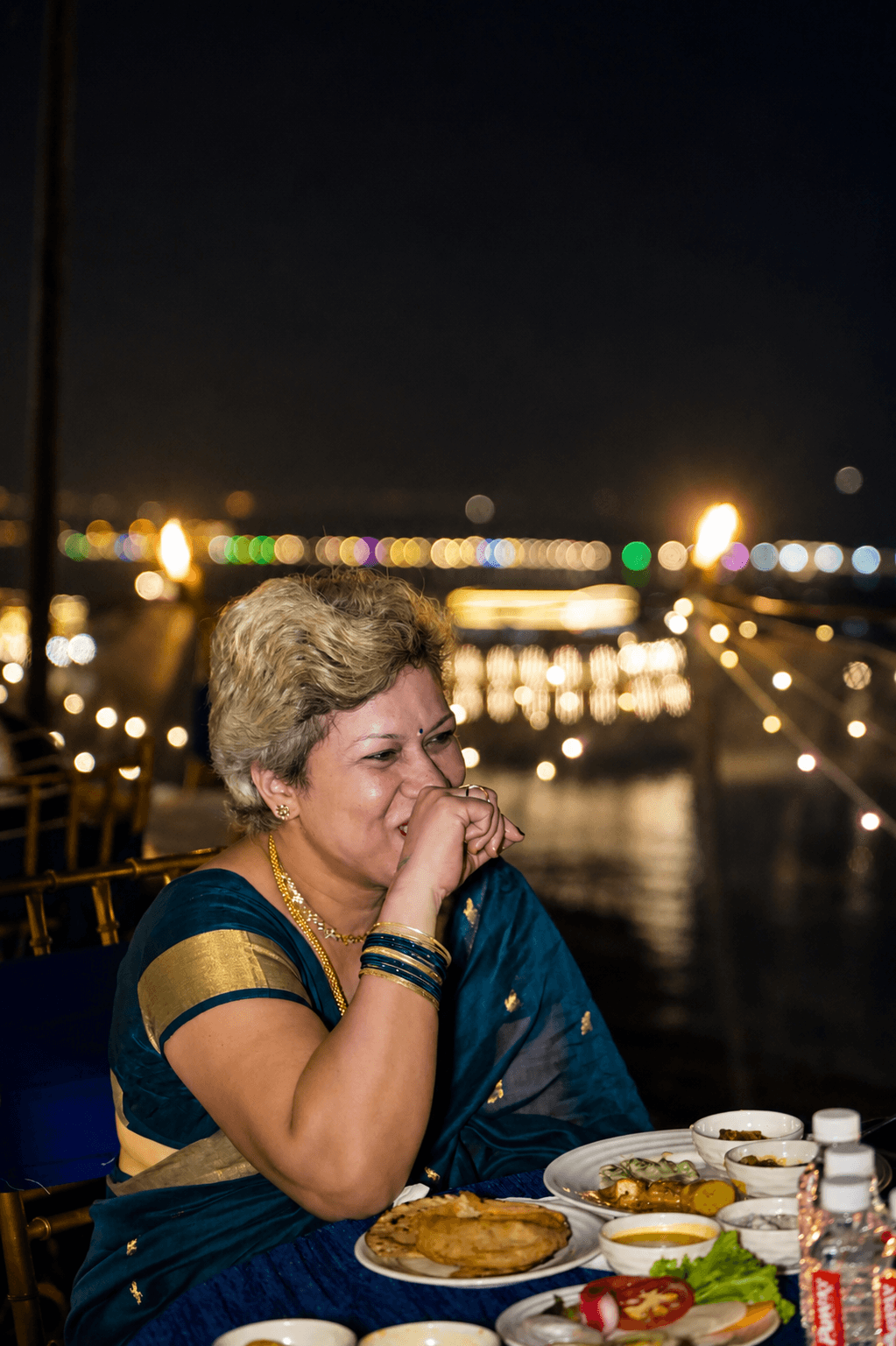 A guest dining as the ghats light up across the Ganges