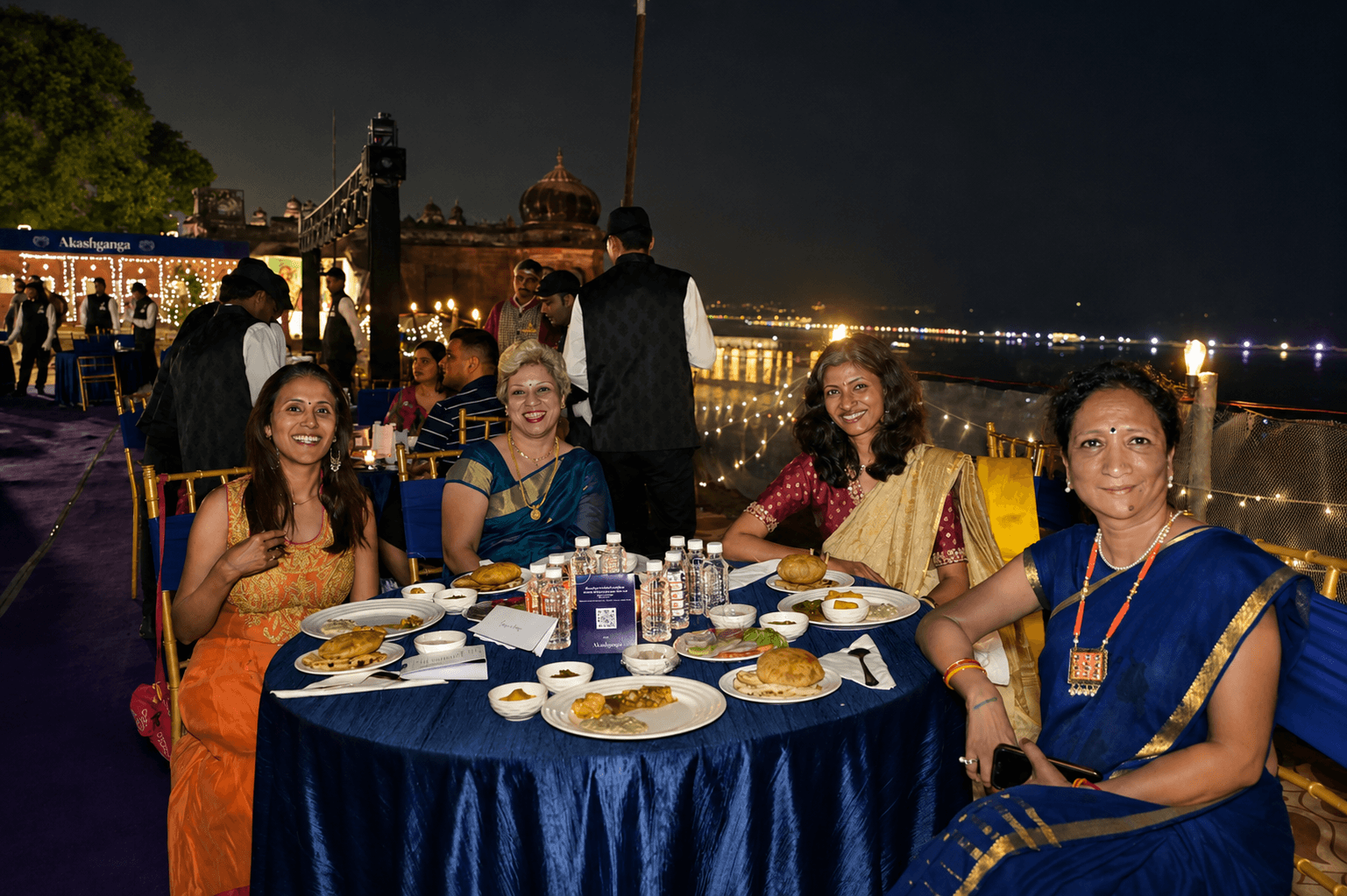 Guests at a riverside dining table